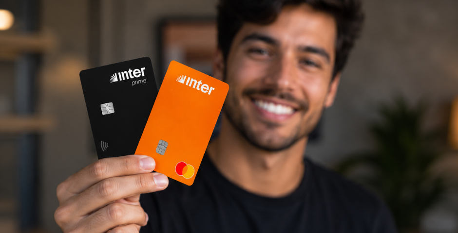 Homem segurando dois Cartões de crédito do Banco Inter