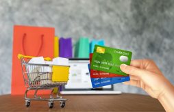 lojas que emitem cartão de crédito na hora - um carrinho de compras e uma mão segurando cartões de crédito