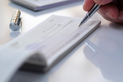 pessoa assinando uma folha de cheque para contratar um Empréstimo com cheque