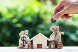 casa em miniatura e dinheiro representando o Consórcio de imóveis
