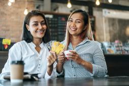 mulheres felizes mostrando um cartão adicional gratuito