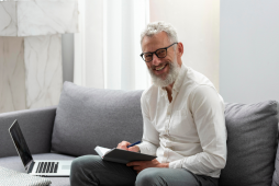 homem terceira idade feliz com laptop e caderno empréstimo para aposentado