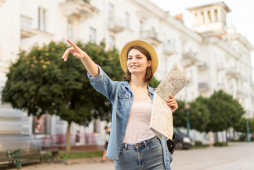 Como viajar de graça - mulher com mapa na mão apontando para a frentecom o dedo