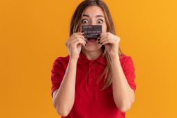 mulher segurando cartão de crédito com limite de R$ 3 mil