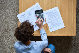 um homem usando uma calculadora para fazer o imposto de renda MEI