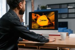 homem sentado em frente ao computador visualizando uma imagem escrita "betano"- Jogo de aposta para ganhar dinheiro: qual é o melhor?