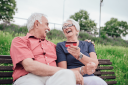Imagem de um casal de idosos sorrindo, segurando um cartão, representando a satisfação ao usar o melhor cartão de crédito consignado