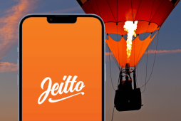 logotipo do Empréstimo Pessoal Jeitto na tela do celular com um balão de ar laranja no fundo