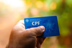uma pessoa segurando um cartão CPF para ilustrar a situação cadastral do CPF