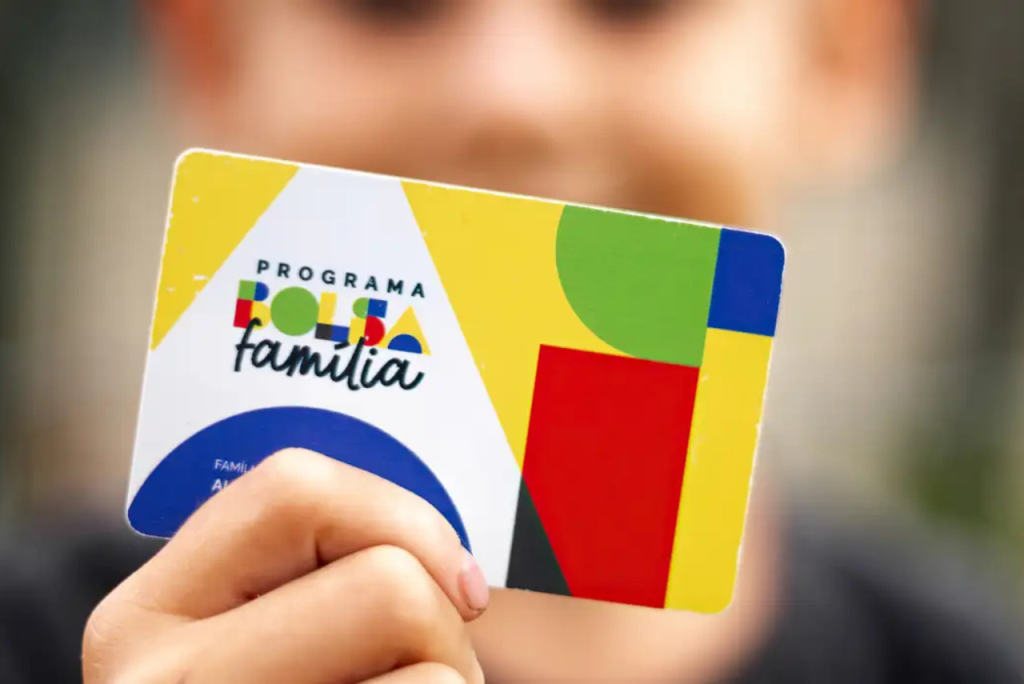 Mão segurando o cartão do programa Bolsa Família