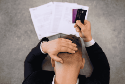 homem segurando cartão com expressão de preocupação para representar a Dívida de cartão de crédito pode bloquear CPF