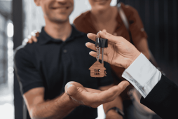 homem recebendo a chave de uma casa após planejar compras grandes