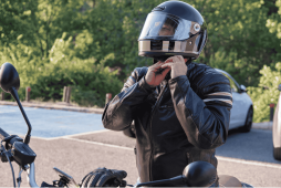 um motociclista colocando o capacete para evitar a multa sem capacete