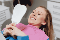 mulher sorrindo após fazer um Implante dentário valor