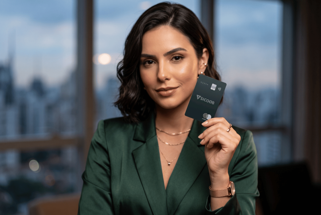 uma mulher elegante segurando o cartão Sicoob Black Verth
