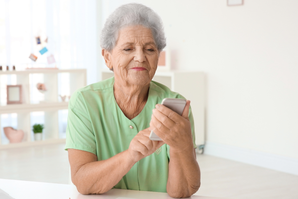 Aposentada usando o celular em casa para contratar Santander Crédito Consignado INSS
